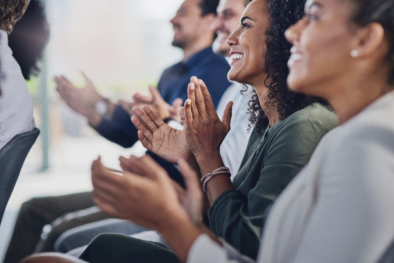 A group of people clapping

Description automatically generated