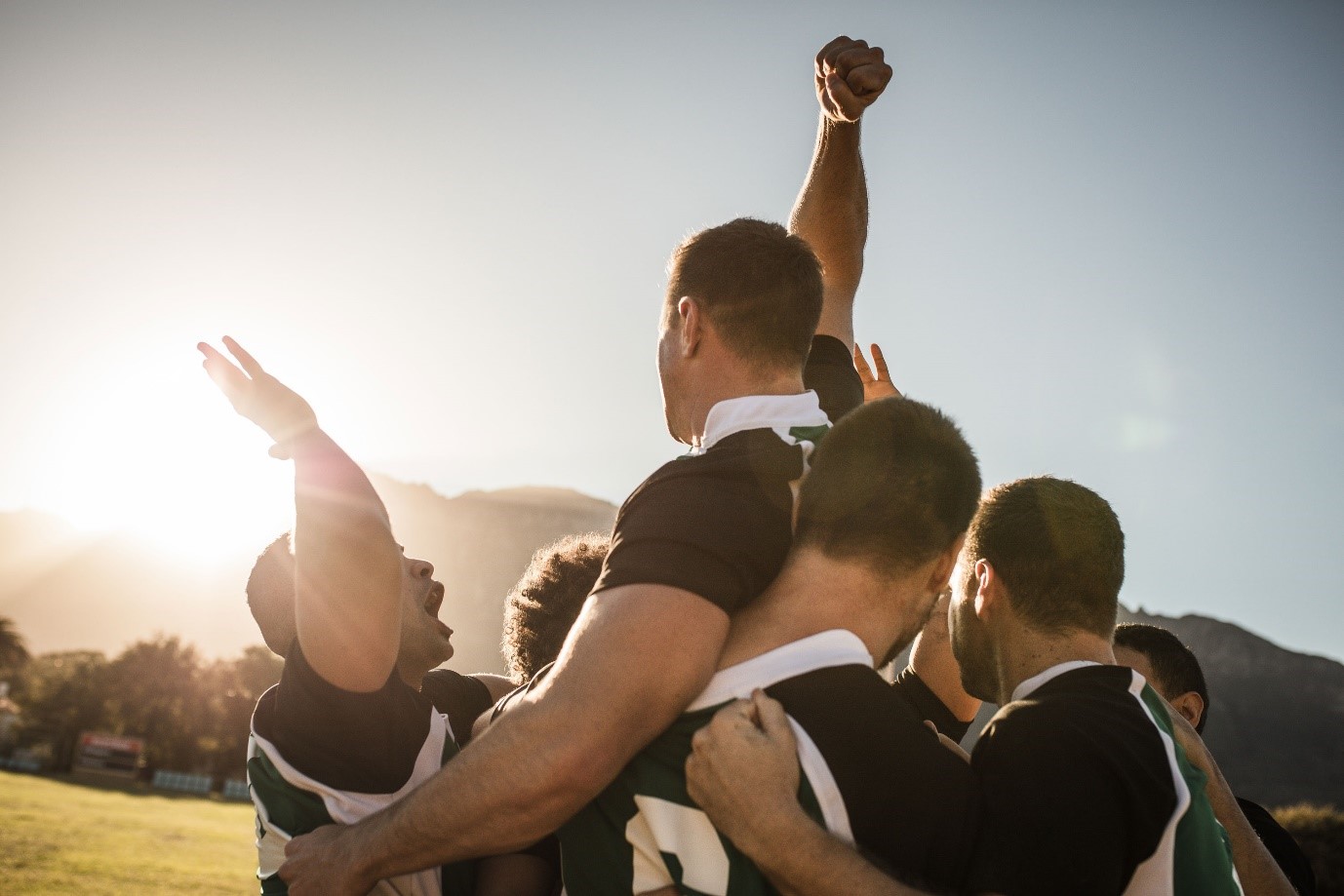 A group of men holding each other

Description automatically generated
